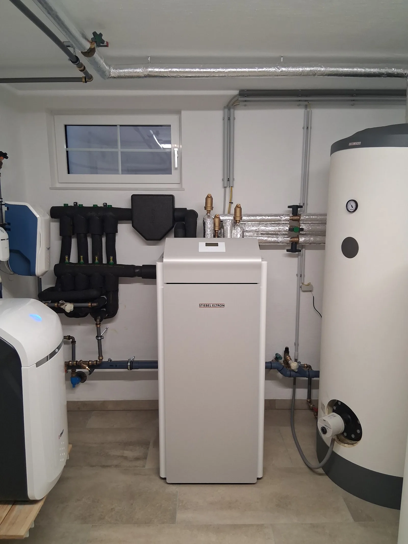 Heizraum mit Stiebel-Eltron-Wärmepumpe, großem Speicher und isoliertem Verteiler